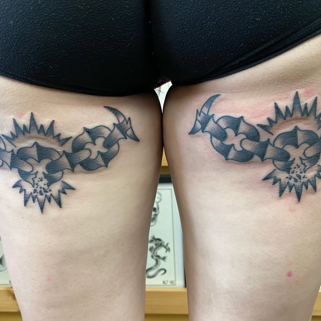 Matching sun and chain tattoos on the thighs by Marshall